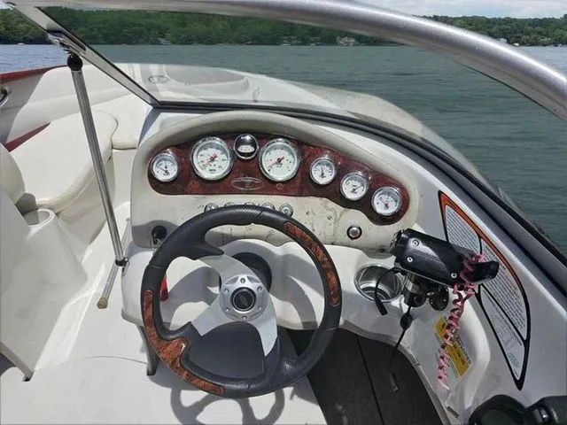 Slide: The Image of 2013 Tahoe Q5i boat dashboard with steering wheel and gauges on a lake. - 8