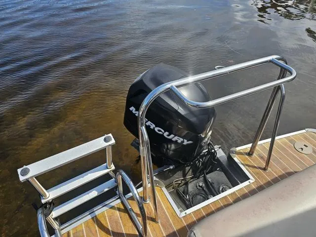 Slide: The Image of 2012 South Bay 522 CR boat with Mercury outboard motor and swim ladder on calm water. - 12