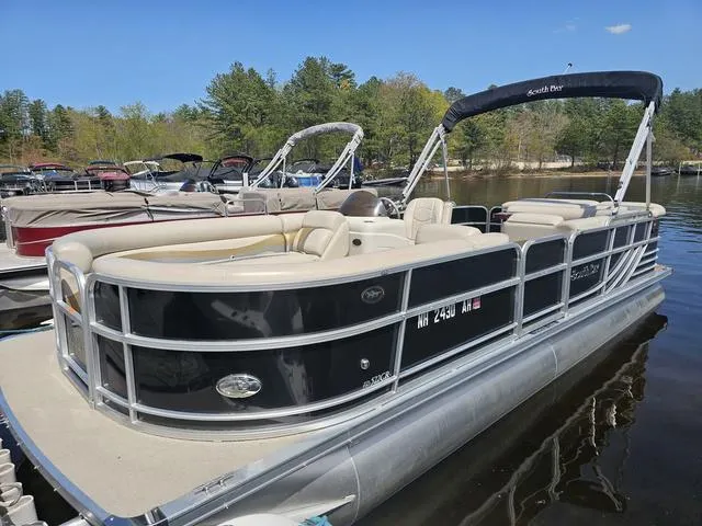 Slide: The Image of 2012 South Bay 522 CR pontoon boat docked on a calm lake with trees in the background. - 3