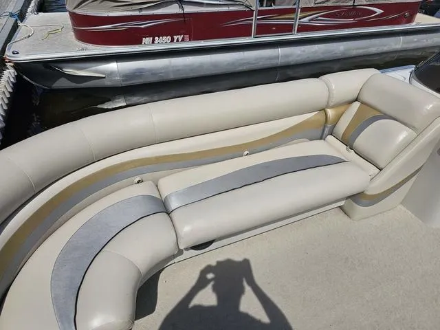 Slide: The Image of 2012 South Bay 522 CR pontoon boat with beige and gray seating, docked beside another boat. - 5