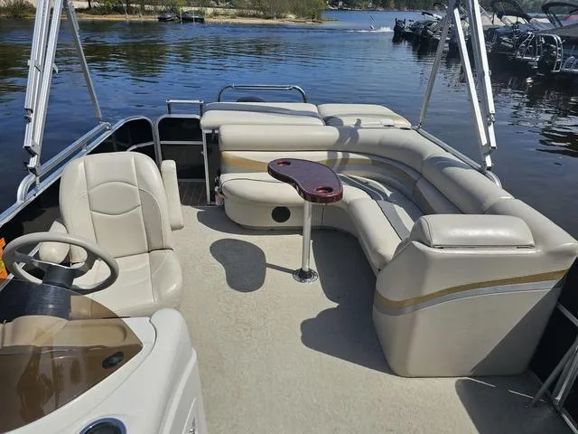 Slide: The Image of 2012 South Bay 522 CR pontoon boat with beige seating and a small table on a lake. - 7