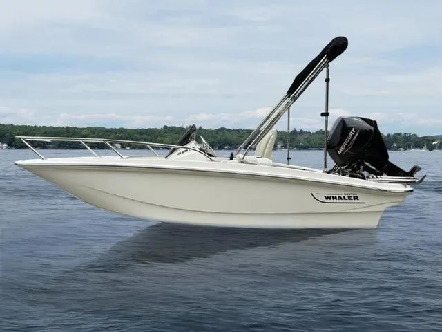 Slide: The Image of 2024 Boston Whaler 130 Super Sport boat on calm water, showcasing sleek design and powerful engine. - 2