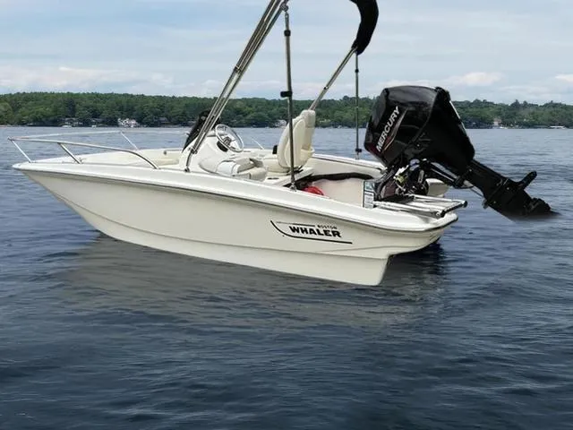 Slide: The Image of 2024 Boston Whaler 130 Super Sport boat on calm lake waters. - 3