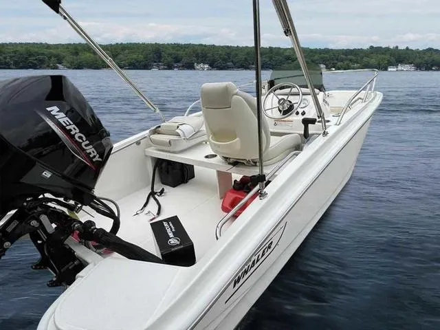 Slide: The Image of 2024 Boston Whaler 130 Super Sport boat on a lake with Mercury engine. - 4