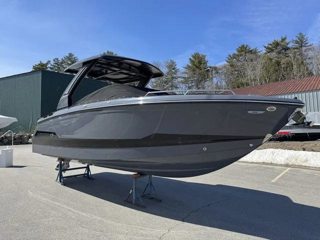 Slide: The Image of 2025 Chaparral 2870 SSX boat displayed outdoors on stands, under clear blue sky. - 1