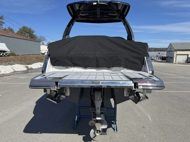 Slide: The Image of 2025 Chaparral 2870 SSX boat, rear view, in a parking lot under clear blue sky. - 4