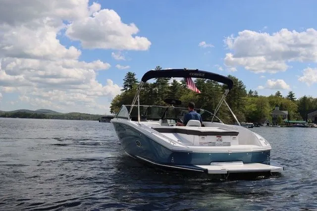 Slide: The Image of 2023 Cobalt CS22 boat cruising on a lake under a partly cloudy sky. - 10
