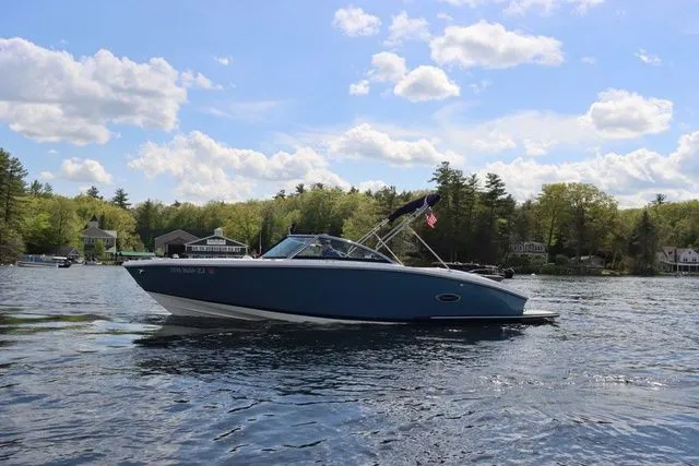 Slide: The Image of 2023 Cobalt CS22 boat on a scenic lake with trees and houses in the background. - 15