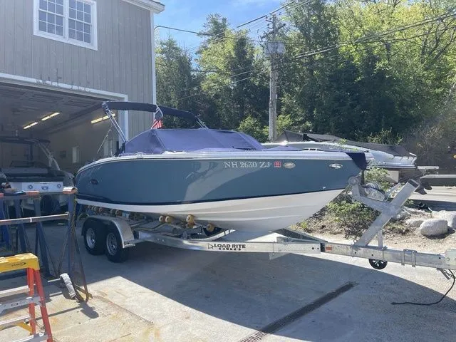 Slide: The Image of 2023 Cobalt CS22 boat on trailer outside a garage, ready for transport. - 17