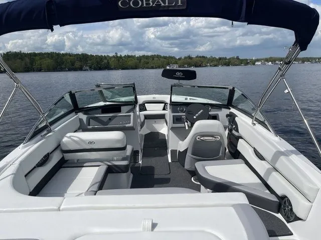 Slide: The Image of 2023 Cobalt CS22 boat interior with seating, steering wheel, and lake view. - 19