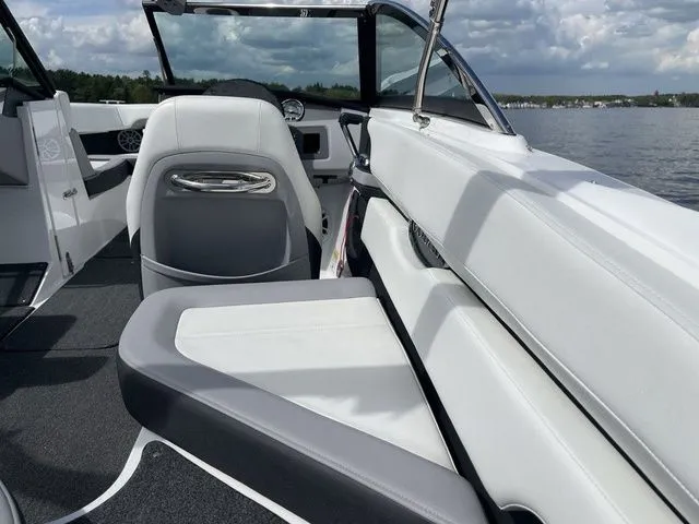 Slide: The Image of 2023 Cobalt CS22 boat interior with white and gray seating on a lake. - 24