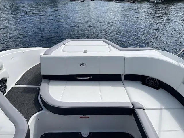 Slide: The Image of 2023 Cobalt CS22 boat interior with white seating, on a calm lake. - 25