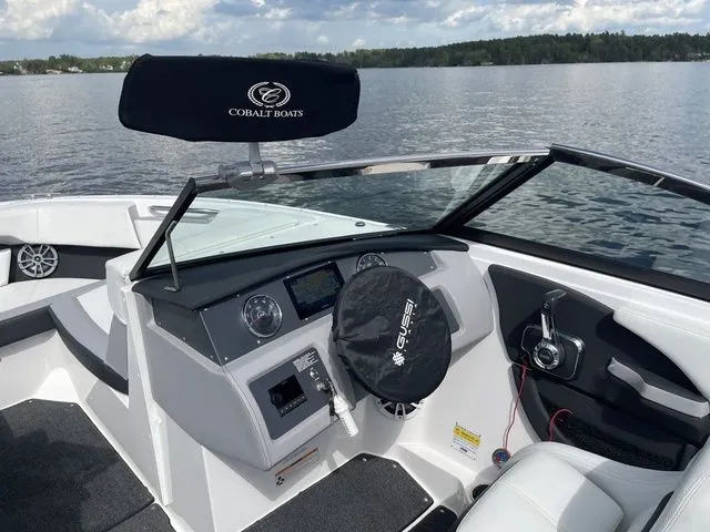 Slide: The Image of 2023 Cobalt CS22 boat dashboard with steering wheel, controls, and lake view. - 28