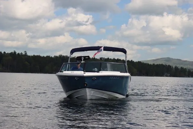 Slide: The Image of 2023 Cobalt CS22 boat cruising on a lake under a cloudy sky. - 3