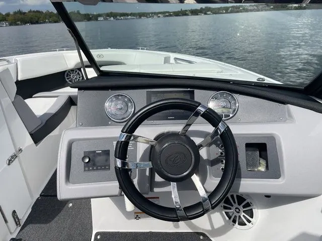 Slide: The Image of 2023 Cobalt CS22 boat dashboard with steering wheel, gauges, and lake view. - 31