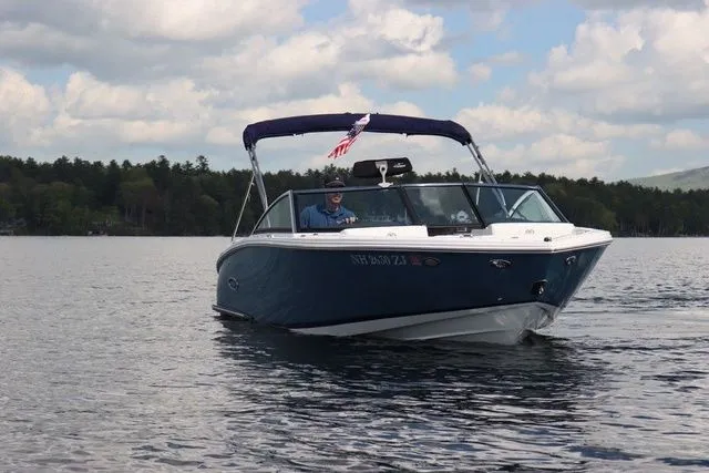 Slide: The Image of 2023 Cobalt CS22 boat cruising on a lake under a cloudy sky. - 4