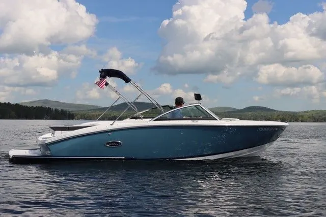 Slide: The Image of 2023 Cobalt CS22 boat cruising on a lake under a cloudy sky. - 5