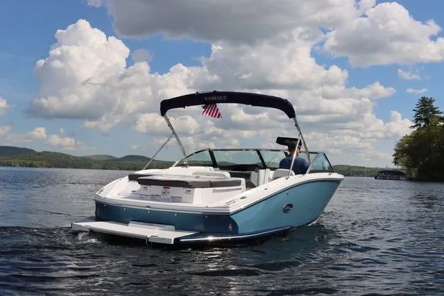 Slide: The Image of 2023 Cobalt CS22 boat cruising on a scenic lake under a partly cloudy sky. - 7