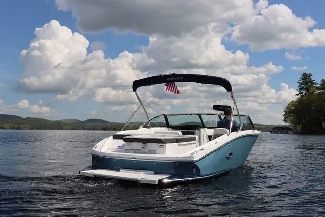 Slide: The Image of 2023 Cobalt CS22 boat cruising on a lake under a partly cloudy sky. - 8