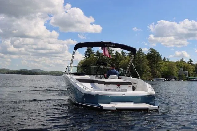 Slide: The Image of 2023 Cobalt CS22 boat cruising on a scenic lake under a partly cloudy sky. - 9