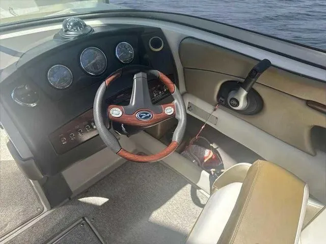 Slide: The Image of 2007 Sea Ray 210 Select boat dashboard with steering wheel and control panel. - 12