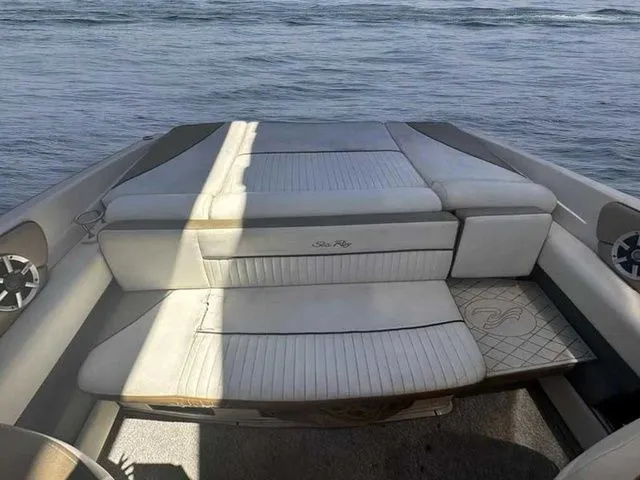 Slide: The Image of 2007 Sea Ray 210 Select boat interior with cushioned seating, on calm water. - 2