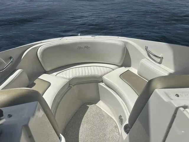 Slide: The Image of 2007 Sea Ray 210 Select boat interior with cushioned seating, on calm water. - 9
