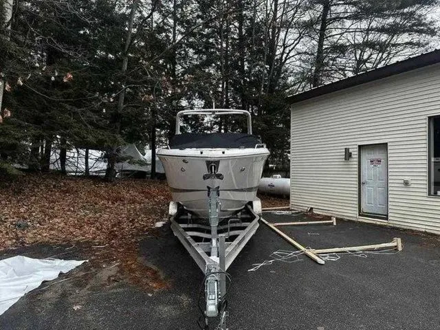 Slide: The Image of 2019 Chaparral 277SX boat on trailer beside a building, surrounded by trees. - 5