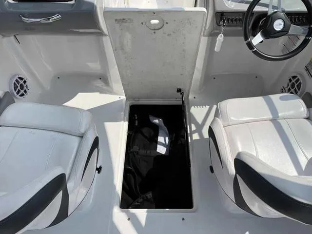 Slide: The Image of Interior of 2021 Chaparral 21 SSI Sport boat showing storage compartment between seats. - 11