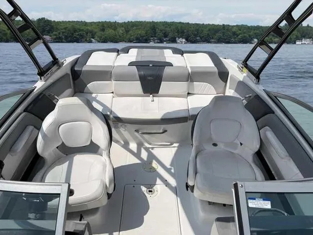 Slide: The Image of 2021 Chaparral 21 SSI Sport boat interior with seating, on a lake. - 17