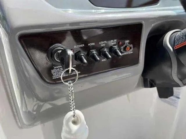 Slide: The Image of Control panel of a 2021 Chaparral 21 SSI Sport boat with key and switches. - 18