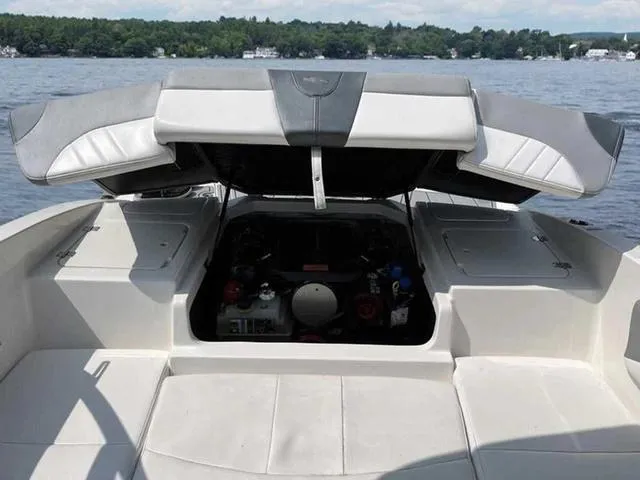 Slide: The Image of 2021 Chaparral 21 SSI Sport boat with open engine compartment on a lake. - 21