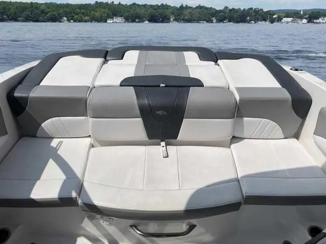 Slide: The Image of 2021 Chaparral 21 SSI Sport boat interior with cushioned seating on a lake. - 23
