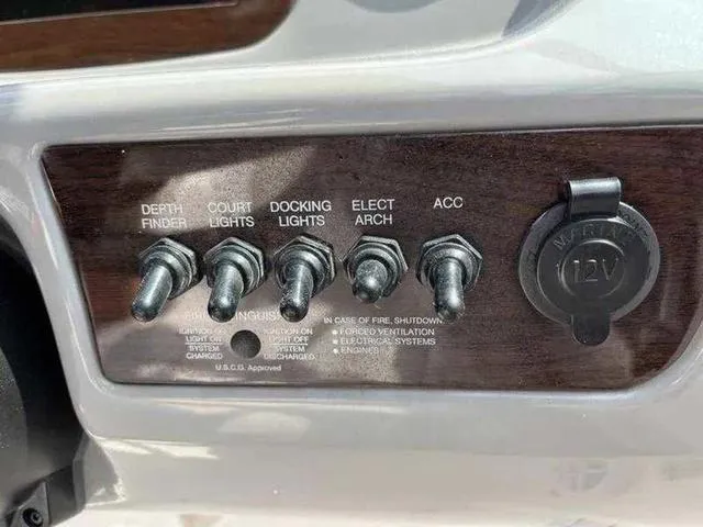 Slide: The Image of Control panel of a 2021 Chaparral 21 SSI Sport boat with labeled switches and 12V outlet. - 27