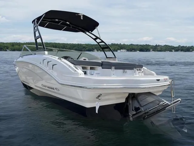Slide: The Image of 2021 Chaparral 21 SSI Sport boat on a lake, featuring sleek design and black canopy. - 5