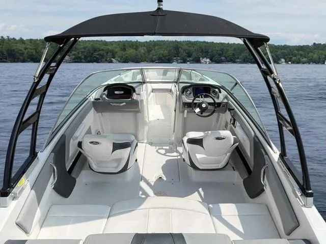 Slide: The Image of 2021 Chaparral 21 SSI Sport boat interior with seating and steering wheel on a lake. - 6