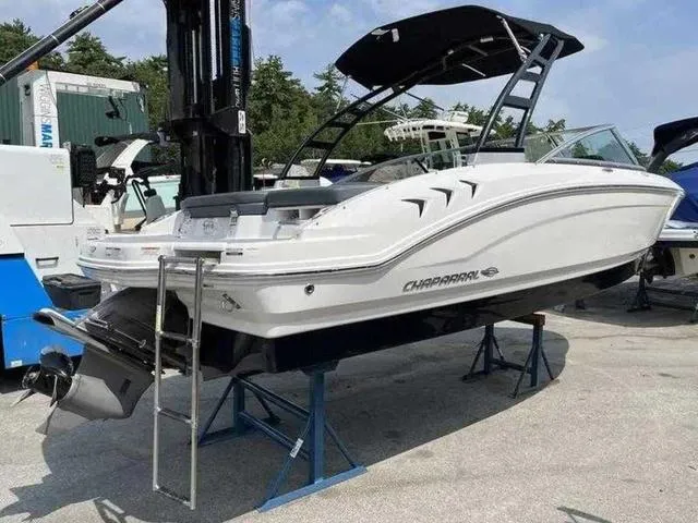 Slide: The Image of 2021 Chaparral 21 SSI Sport boat on display, elevated on stands, with a sleek white design. - 9
