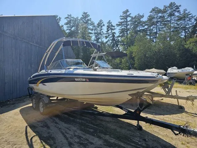 Slide: The Image of 2007 Four Winns Horizon 220 boat on trailer near a wooden barn and trees. - 1