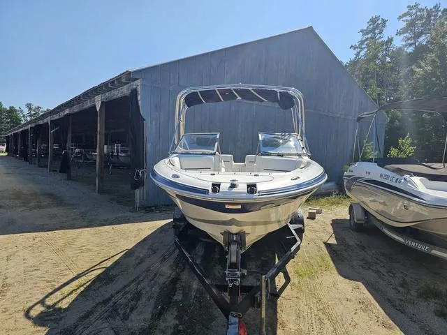 Slide: The Image of 2007 Four Winns Horizon 220 boat on trailer near a wooden shed. - 2