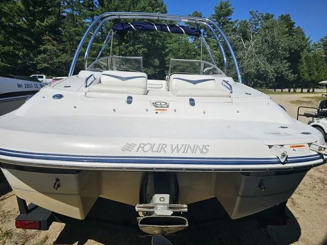 Slide: The Image of 2007 Four Winns Horizon 220 boat, rear view, parked on sandy ground with trees in background. - 4