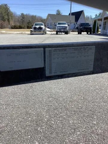 Slide: The Image of 2007 Bayliner HSP 190 boat on trailer, parked outdoors with vehicles and buildings in the background. - 20