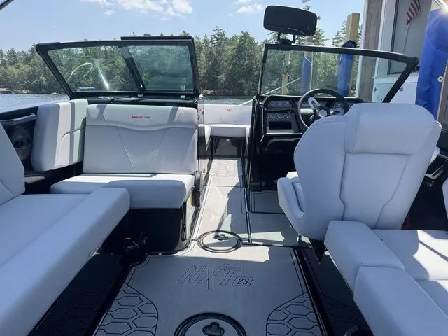 Slide: The Image of 2024 MasterCraft NXT23 boat interior with white seating and modern dashboard. - 12