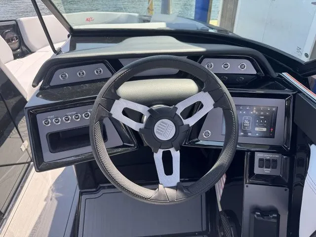 Slide: The Image of 2024 MasterCraft NXT23 boat dashboard with steering wheel and control panel. - 14