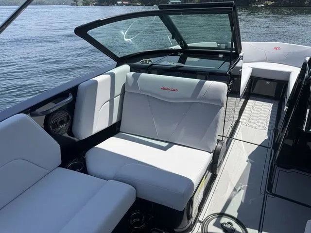 Slide: The Image of 2024 MasterCraft NXT23 boat interior with white seating on a sunny day. - 17