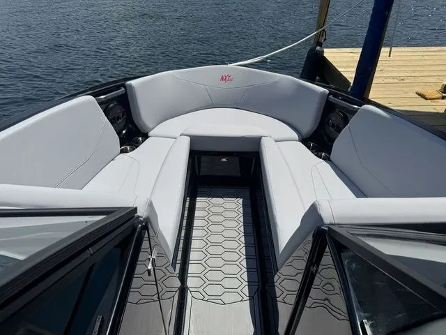 Slide: The Image of 2024 MasterCraft NXT23 boat interior with sleek seating and modern design on the water. - 18