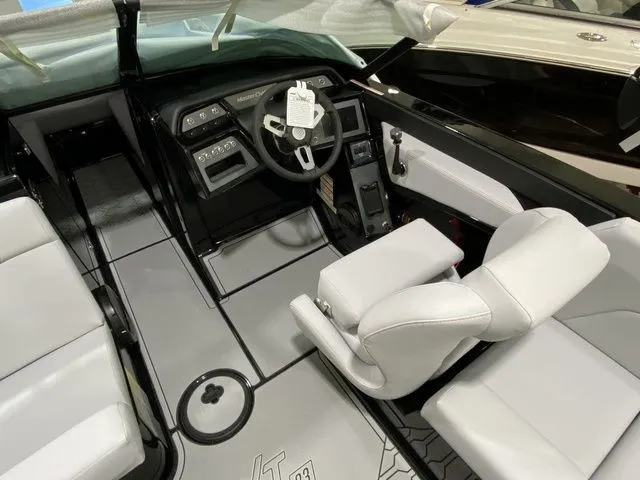 Slide: The Image of 2024 MasterCraft NXT23 boat interior with modern dashboard and white seating. - 21
