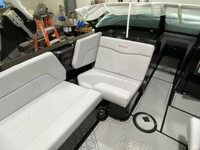 Slide: The Image of 2024 MasterCraft NXT23 boat interior with white seating and modern design. - 22