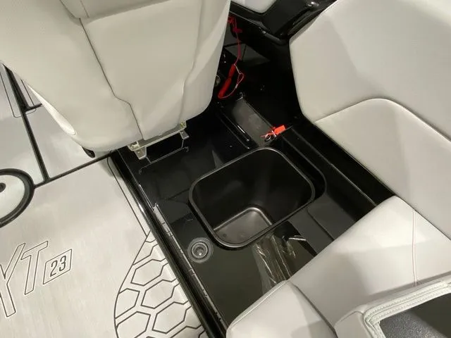 Slide: The Image of 2024 MasterCraft NXT23 boat interior with storage compartment and seating. - 25