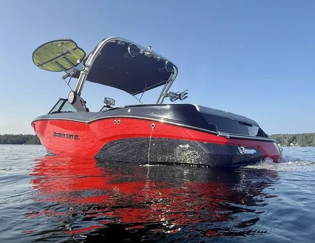 Slide: The Image of 2024 MasterCraft NXT23 boat on water, featuring sleek red and black design. - 6