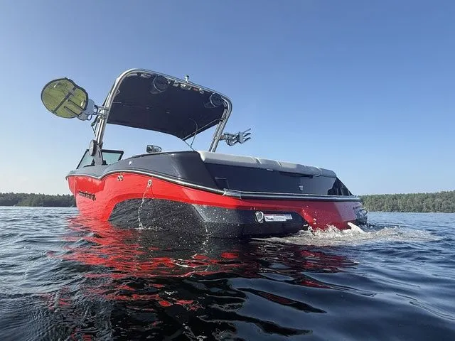 Slide: The Image of 2024 MasterCraft NXT23 boat on water, red and black design, sunny day. - 7